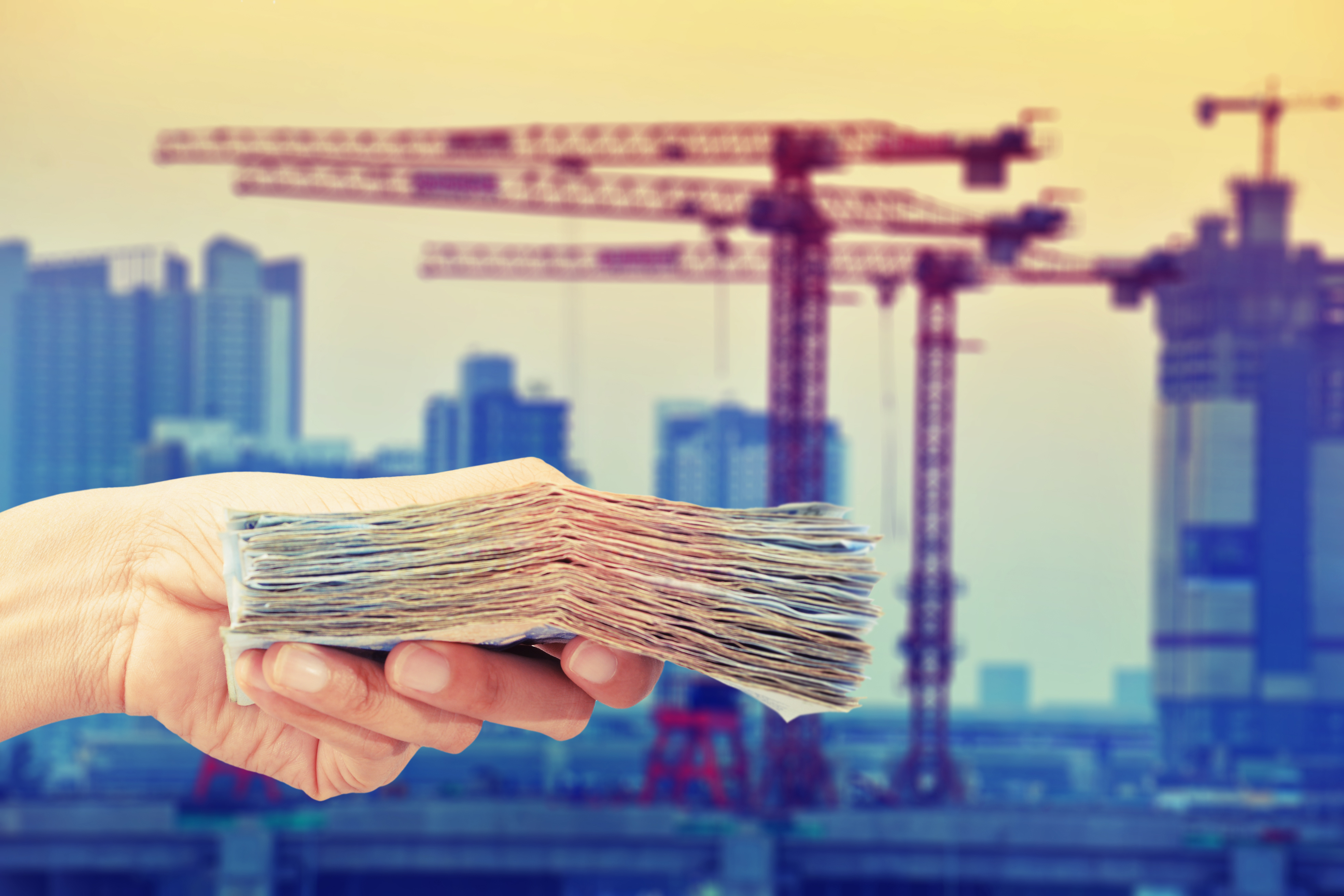 Handing over funds with cranes in background